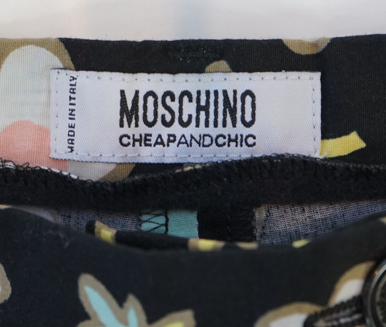 A Moschino lady's long blue and red jacket, a cream cotton embellished blazer and a cotton pair of floral trousers, blue and red jacket size 14, cream blazer size 12, trousers size: 10